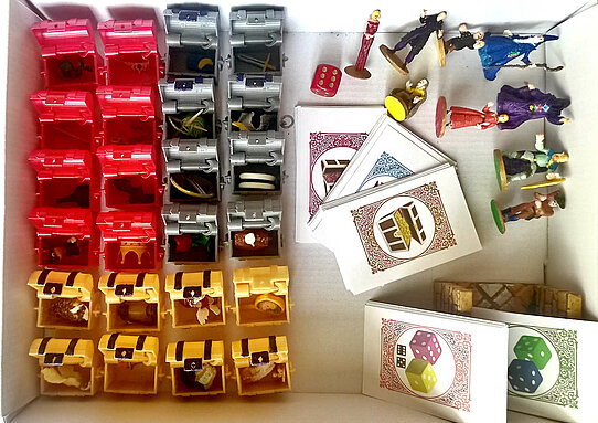 Top view of the opened treasure chests with treasures inside, cards and pawns