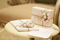 Bright gifts with pink roses decorated with letter on a small table